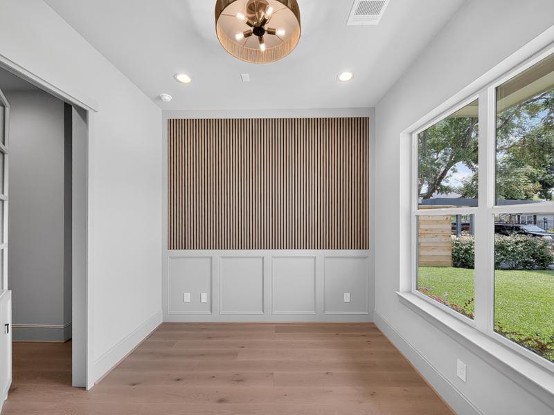 Bright room with a wood-slat accent wall and tall windows.