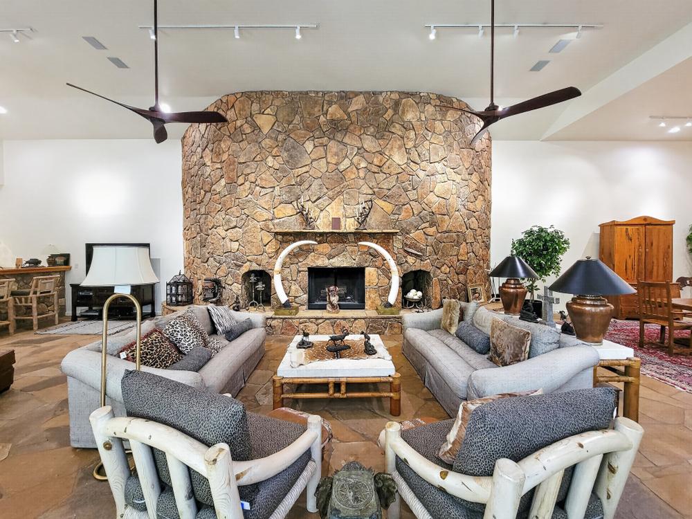Spacious living room with a stone fireplace and seating.