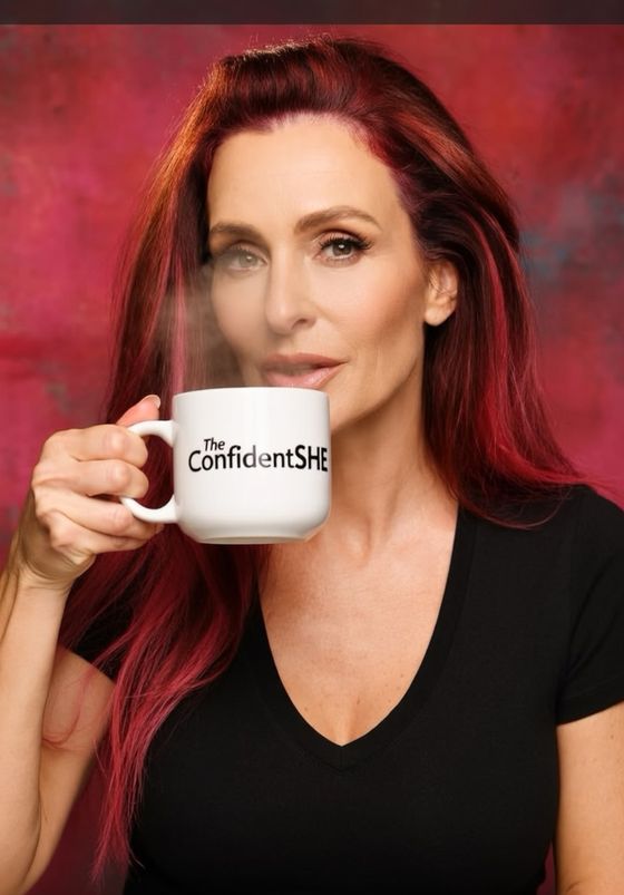 Parker holding a ConfidentSHE mug