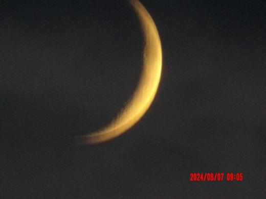 A golden crescent moon against a dark sky