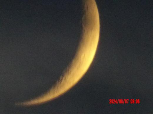 A golden crescent moon against a dark sky